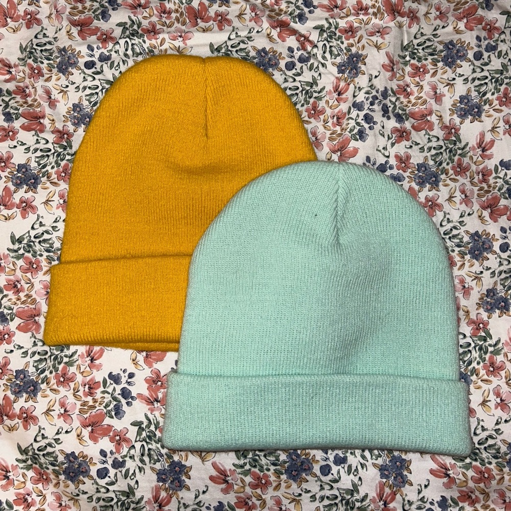 Two beanies. One mustard yellow. One teal blue.